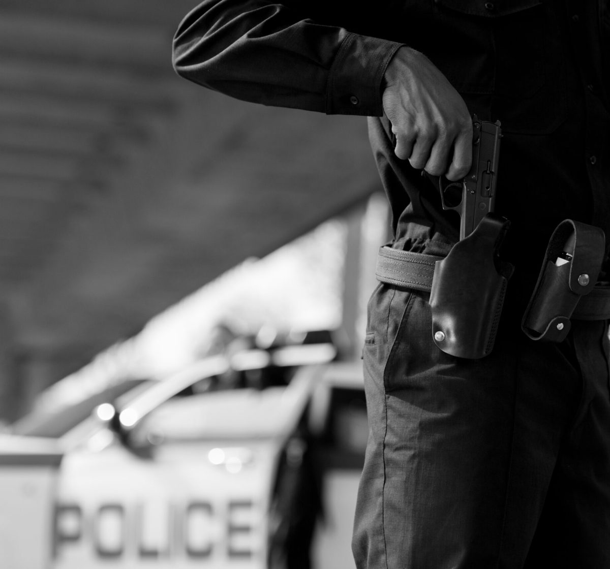 cropped shot of police officer taking out gun